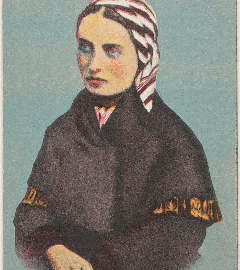 Hand-tinted postcard portrait of a young woman in a dark shawl and a striped headscarf, looking at the camera